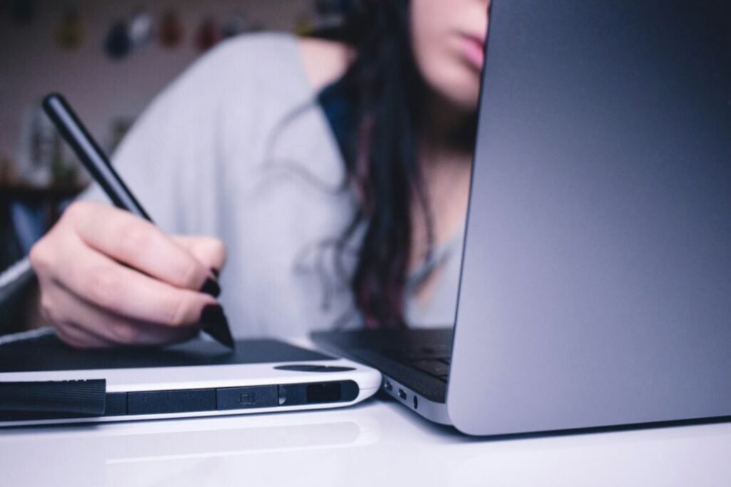 Diseñadora trabaja con una tableta y una computadora.