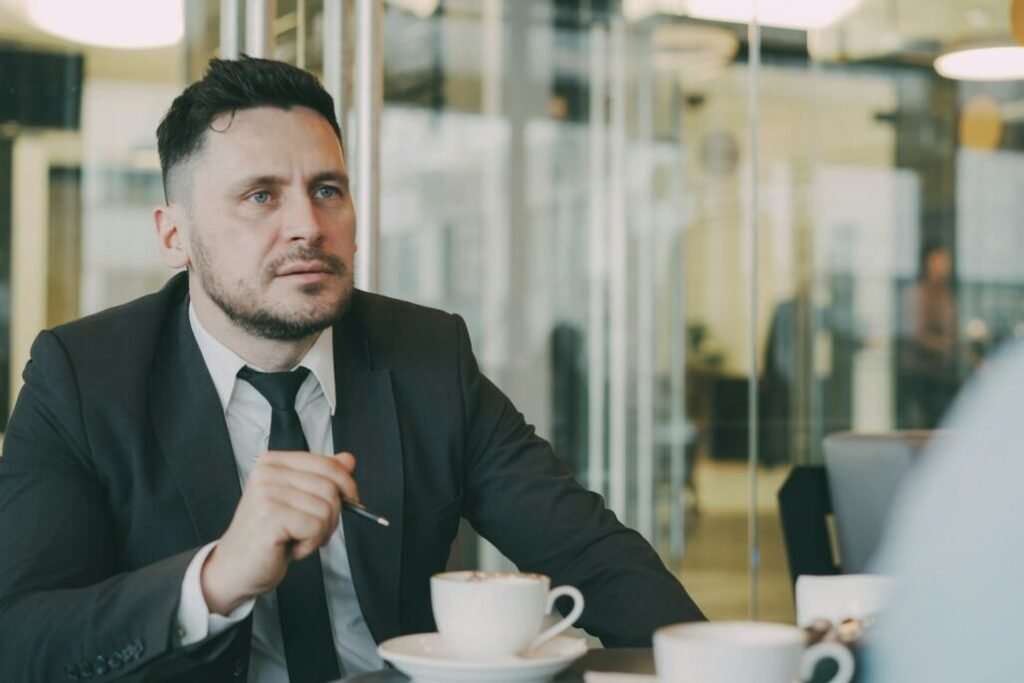Profesional conversa sentado a una mesa durante una reunión.